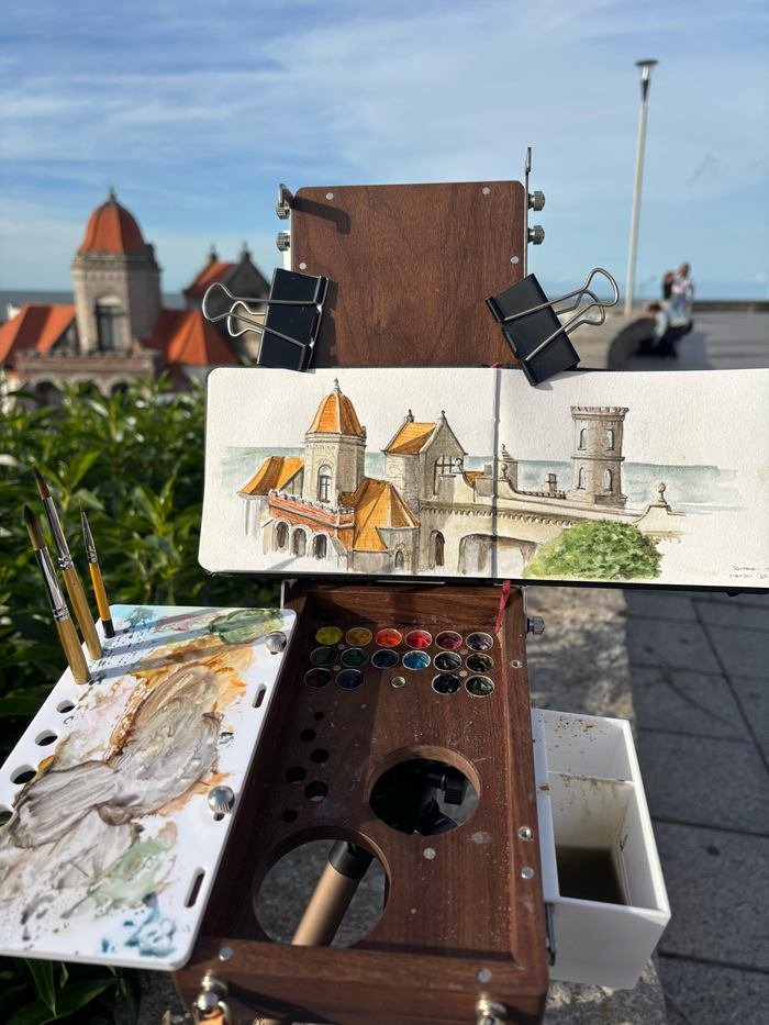 Sketchbook con el Torreón del Monje en acuarela, junto a la caja de acuarelas abierta sobre los tejados