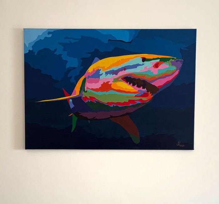 Pintura de un tiburón de colores sobre fondo azul, colgada en una pared